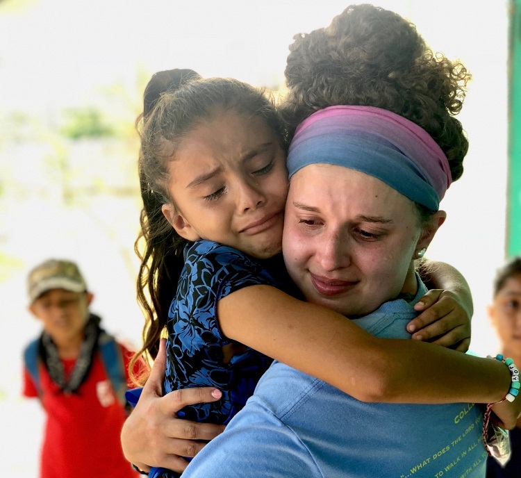 little Belize girl tearfully hugging a player goodbye