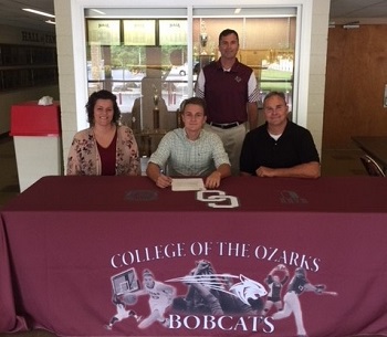 Klay Barton seated with his parents on either side and Coach Shepherd standing in the back row