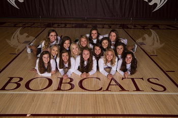 Lady Bobcats frouped on the floor looking up at the camera